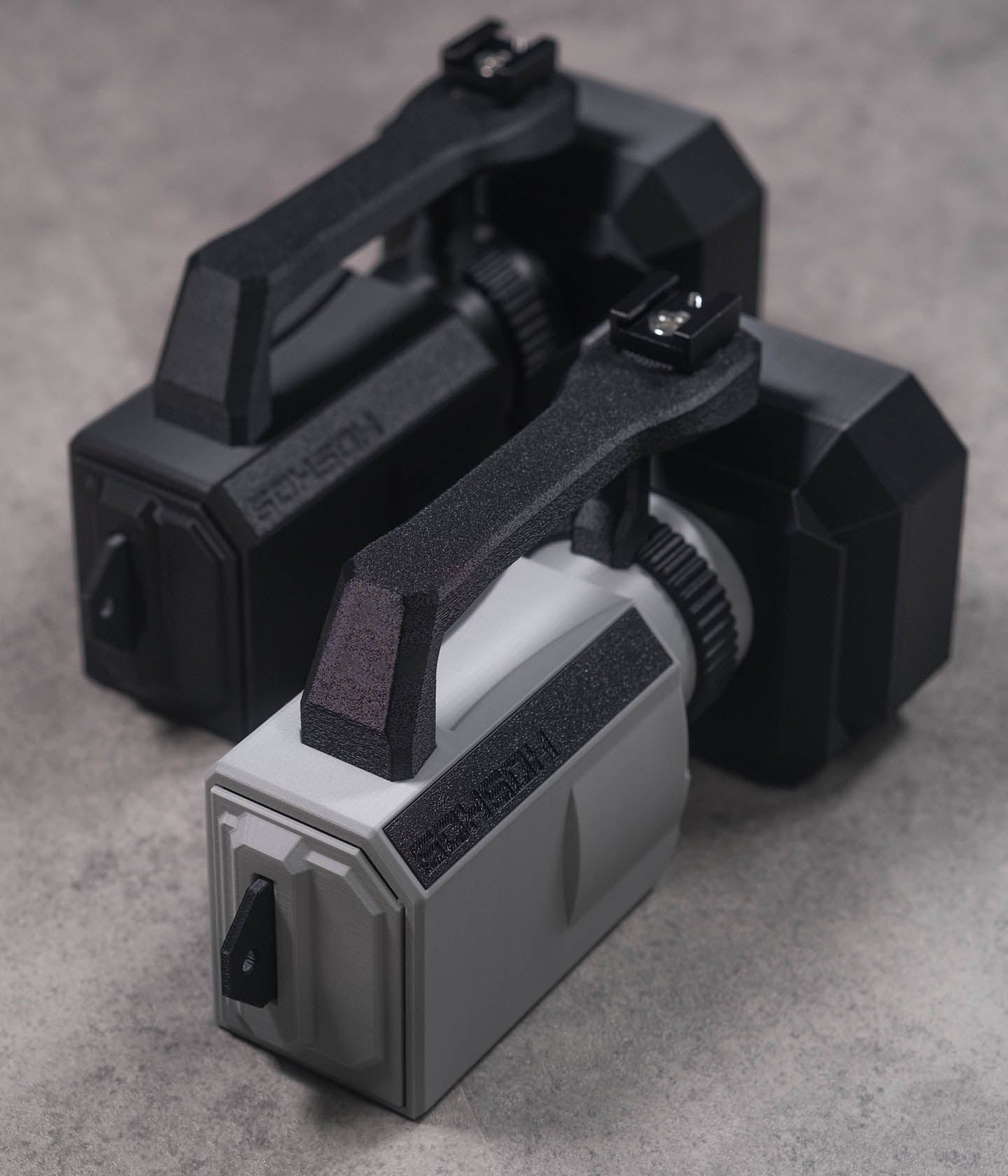 Mini VX™ 3D-printed action camera cage for GoPro, DJI Action and Insta360 — VX1000-style skate filming rig. Black and Grey Versions